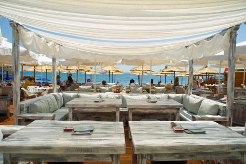 un restaurante en la playa con mesas y sombrillas en Hotel Astoria en Budva