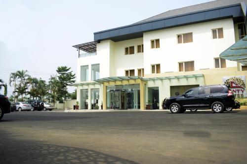 a black suv parked in front of a building at Monty Suites & Golf in Uyo