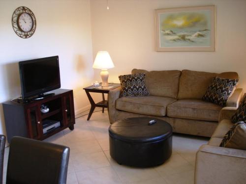 a living room with a couch and a tv at Midnight Cove #532, Bayside in Siesta Key, FL in Siesta Key