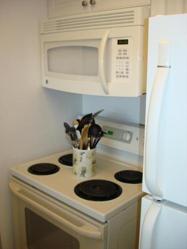 a kitchen with a stove top oven with a microwave at Midnight Cove #532, Bayside in Siesta Key, FL in Siesta Key