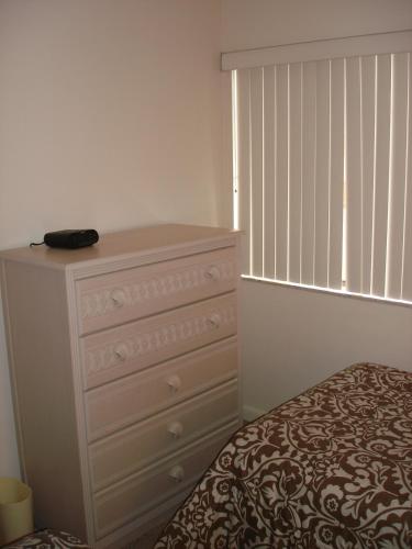 a bedroom with a dresser and a bed with a window at Midnight Cove #532, Bayside in Siesta Key, FL in Siesta Key