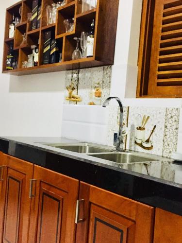 a kitchen with a sink and wooden cabinets at Villa 252 Kosgoda in Kosgoda