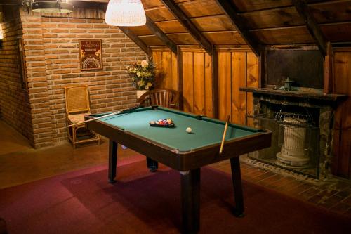 a room with a pool table and a fireplace at Cabañas Hosteria de Vilches in Vilches
