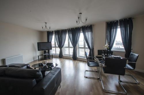 a living room with a couch and a table and chairs at City Centre Orange Apartments - Portland Street in Aberdeen