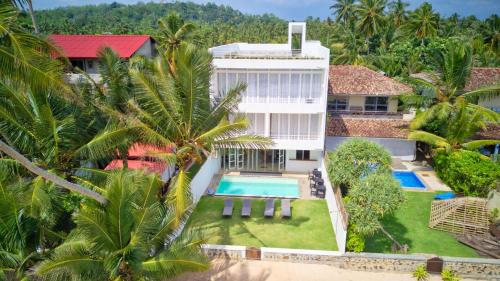 an aerial view of a house with a swimming pool and palm trees at Bieshu Beach Hive in Habaraduwa