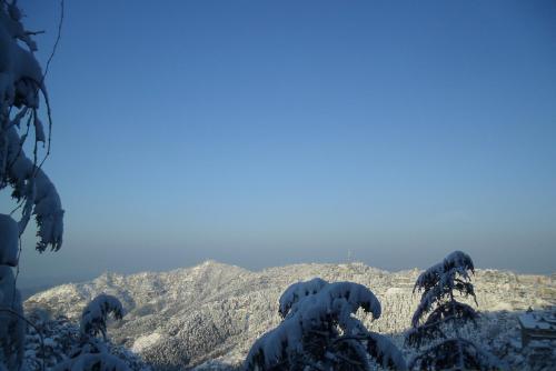 a mountain covered in snow with the sky in the background at Honeymoon Inn Shimla in Shimla