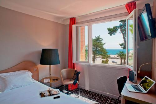 Cette chambre d'hôtel dispose d'une fenêtre avec vue sur l'océan. dans l'établissement Hôtel Beau Rivage, à Argelès-sur-Mer