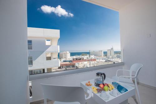 Habitación con ventana y vistas a la ciudad. en Kokkinos Boutique Hotel, en Protaras