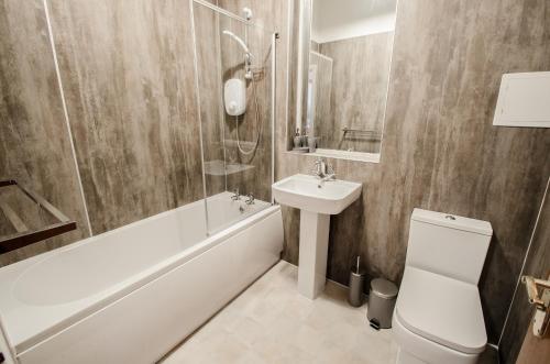 uma casa de banho com um lavatório, um WC e uma banheira em City Centre Orange Apartments Bastille em Aberdeen