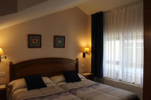 a bedroom with a bed and a window at Apartamentos La Lula in Cudillero