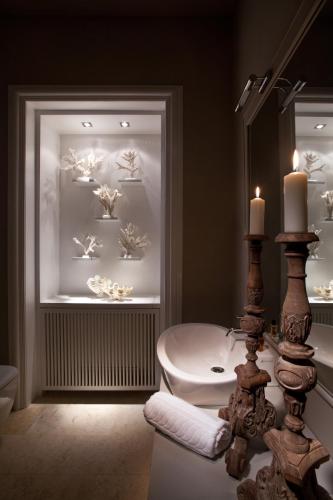 a bathroom with a sink and a toilet and a window at Seven Rooms Villadorata in Noto