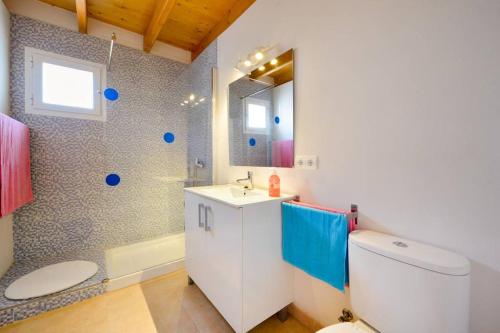 bagno con servizi igienici, lavandino e specchio di Sa Caseta La Casita a La Savina