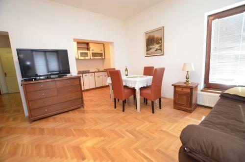 a living room with a table with chairs and a television at Mladenovic apartments in Kladovo
