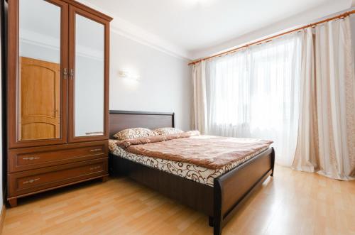 ein Schlafzimmer mit einem Bett, einem Schrank und einem Fenster in der Unterkunft ARTAL Apartment Yordanska Street 22 in Kiew