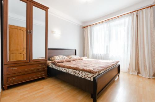 a bedroom with a bed and a cabinet and a window at ARTAL Apartment Yordanska Street 22 in Kyiv