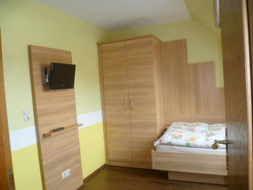 Schlafzimmer mit einem Bett und einem Holzschrank in der Unterkunft Hotel Thünenhof in Oyten