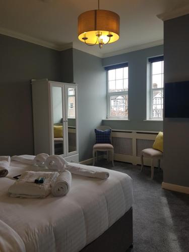 a bedroom with a large bed with towels on it at The Royal Oak in Woodford