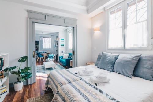 ein Schlafzimmer mit einem Bett und ein Wohnzimmer in der Unterkunft Gran Via Apartment by People Rentals in Bilbao