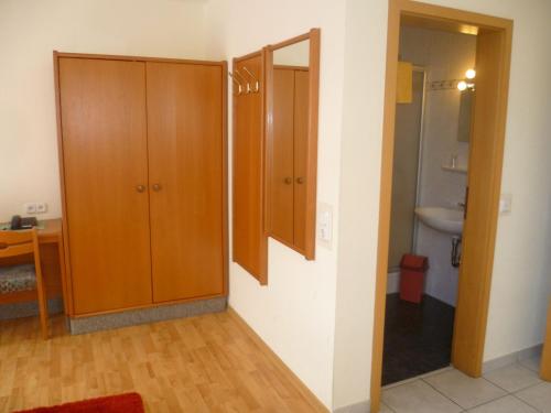 La salle de bains est pourvue d'une armoire en bois et d'un lavabo. dans l'établissement Hotel Thünenhof, à Oyten