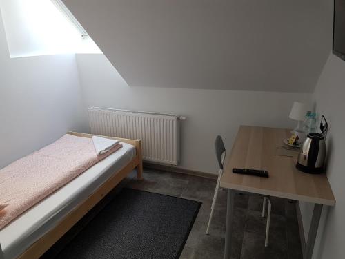 a small bedroom with a bed and a table at Noclegi u Andrzeja in Gdańsk