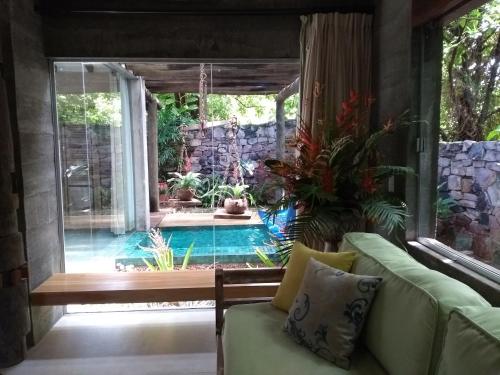 a living room with a couch and a swimming pool at Hotel de Lençois in Lençóis