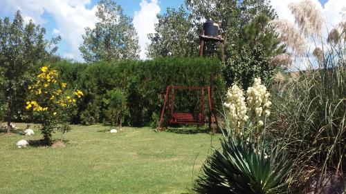 a garden with a red bench in the grass at Cabañas Abigail in Nono