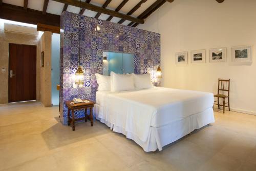 a bedroom with a large bed with a purple wall at Hotel de Lençois in Lençóis