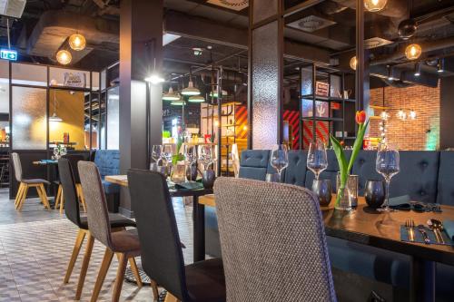 a restaurant with tables and chairs and wine glasses at Park Inn by Radisson Poznan in Poznań