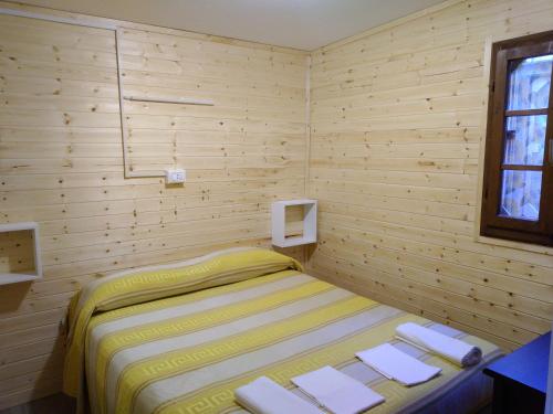 a small bedroom with a bed and a window at Camping Pineta in Calambrone