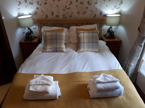 a bedroom with a bed with two towels on it at The Black Bull at Nateby in Kirkby Stephen