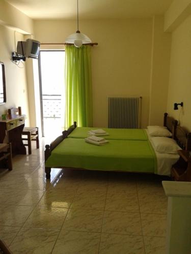 ein Schlafzimmer mit einem grünen Bett und einem Fenster in der Unterkunft Balaska House in Region Ilia