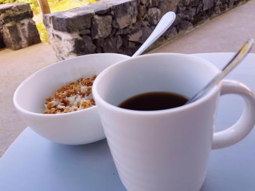 a cup of coffee and a bowl of cereal at Casa dos Caldeiras in Lajes do Pico