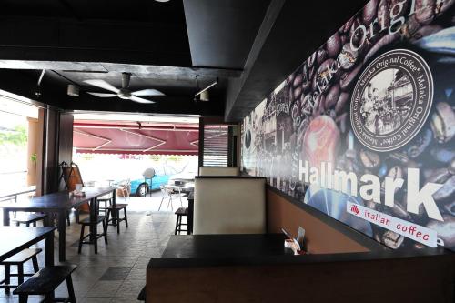 a restaurant with tables and chairs and a sign on the wall at Hallmark Leisure Hotel in Melaka