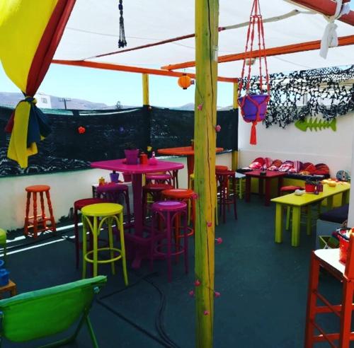 um restaurante com mesas coloridas e bancos numa sala em Viva Margarita em Parikia