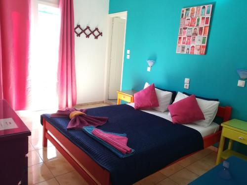 Schlafzimmer mit einem Bett mit rosa und blauen Wänden in der Unterkunft Viva Margarita in Parikia