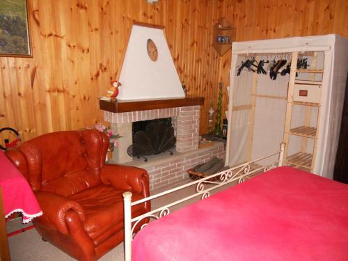 a living room with a chair and a fireplace at B&B Pervinca in Rocca Grimalda