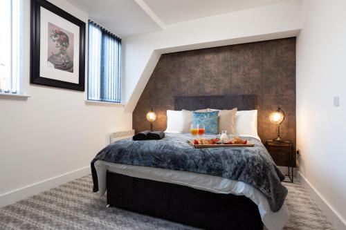 Leeds Super Luxurious Apartments في ليدز: غرفة نوم بها سرير عليه صينية طعام