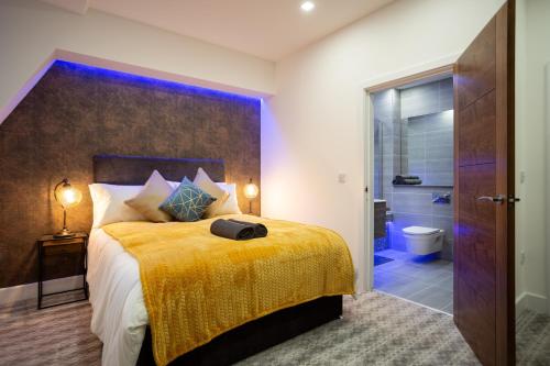 Leeds Super Luxurious Apartments في ليدز: غرفة نوم بسرير كبير مع بطانية صفراء
