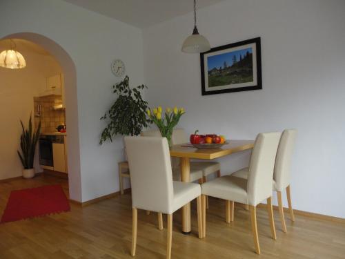 ein Esszimmer mit einem Tisch und weißen Stühlen in der Unterkunft Ferienwohnung Ronacher in Abtenau