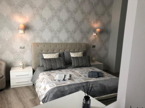 Un dormitorio con una cama grande con dos mesitas de noche. en Masia Holiday Apartment Como Lake, en Como