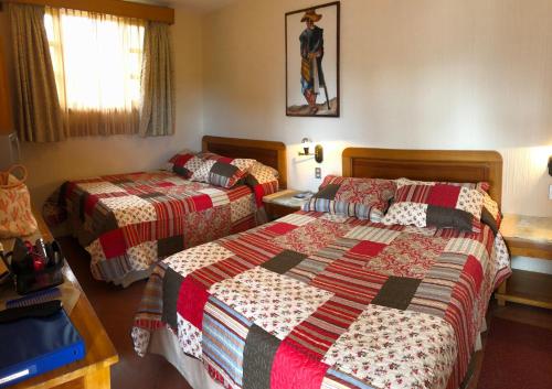um quarto de hotel com duas camas num quarto em Posada De Los Volcanes em Panajachel