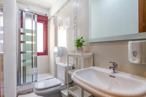 馬德里的住宿－AYZ Javier Cabrini - Auto check-in property，白色的浴室设有水槽和卫生间。
