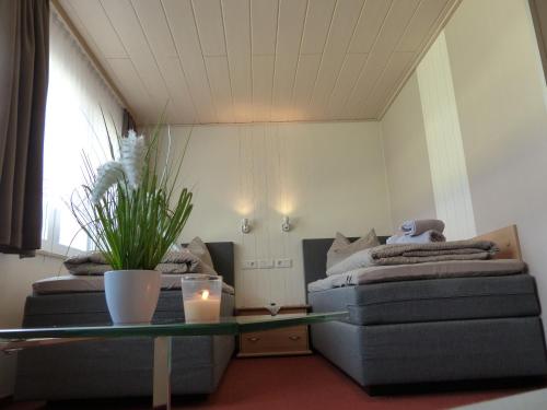 a room with two beds and a table with a candle at Hotel/Restaurant Balkan in Sömmerda