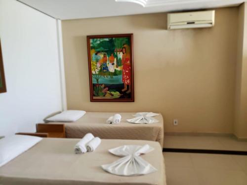 a room with two beds and a painting on the wall at Don Limpone Apart Hotel in Natal