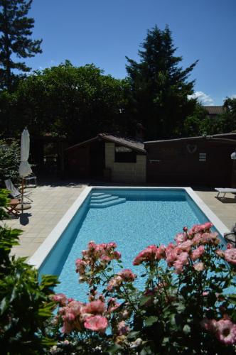 a swimming pool with pink flowers in a yard at Il Fiorile in Borghetto Di Borbera