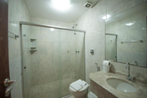 a bathroom with a shower and a toilet and a sink at Estação do Sol Praia Hotel in Porto De Galinhas