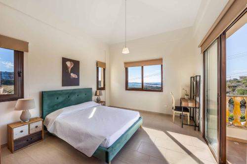 Un dormitorio con una cama y una mesa y ventanas. en Aqua View, en Kissonerga
