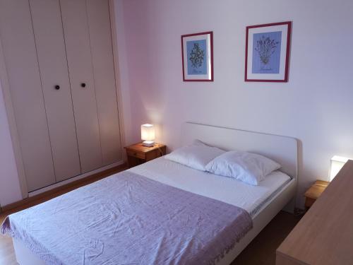 ゴルフ・ジュアンにあるLe Regent's Parkの白いベッド1台と壁に2枚の絵が飾られたベッドルーム1室が備わります。