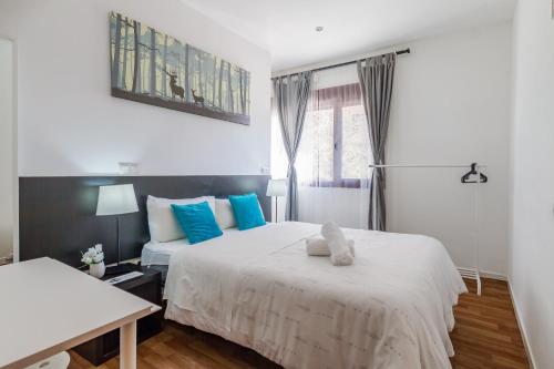 a bedroom with two beds with blue pillows at AYZ Javier Cabrini - Auto check-in property in Madrid