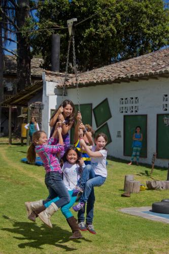 a group of children playing on a swing at Hacienda Hosteria Chorlavi in Ibarra